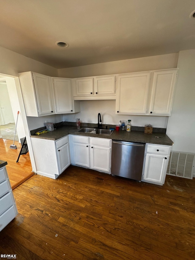 kitchen with visible vents, dark wood-type flooring, a sink, stainless steel dishwasher, and white cabinetry