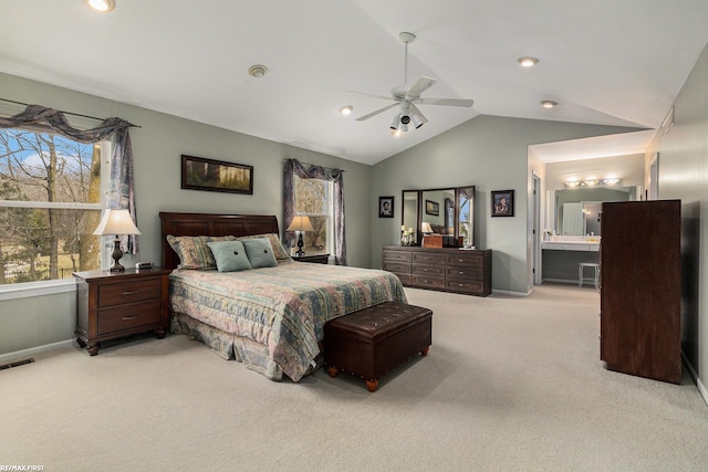 bedroom featuring visible vents, a ceiling fan, ensuite bathroom, carpet floors, and vaulted ceiling