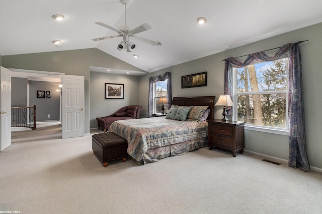 bedroom featuring baseboards, light carpet, lofted ceiling, and ceiling fan