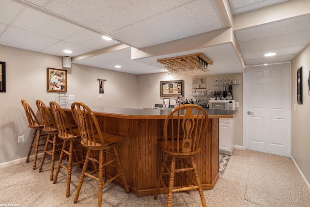 bar with baseboards, recessed lighting, a drop ceiling, bar, and light colored carpet