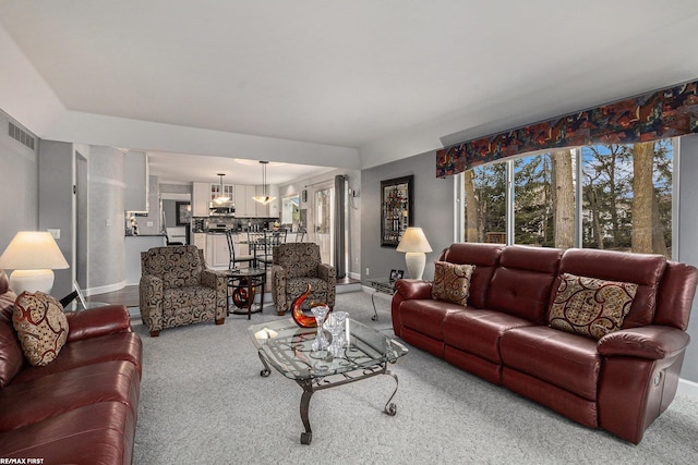 living area featuring visible vents, carpet floors, and baseboards