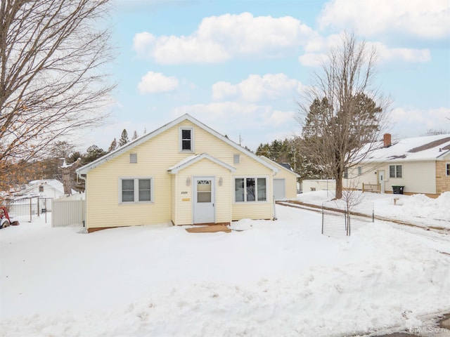 snow covered rear of property with fence