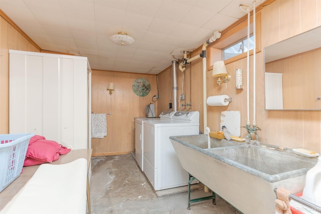 laundry room with washer and dryer, wood walls, laundry area, and a sink