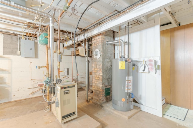 utility room with electric panel, gas water heater, and a heating unit