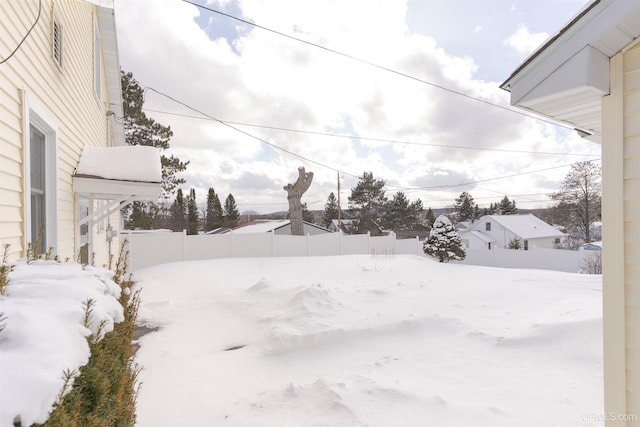 yard layered in snow with fence