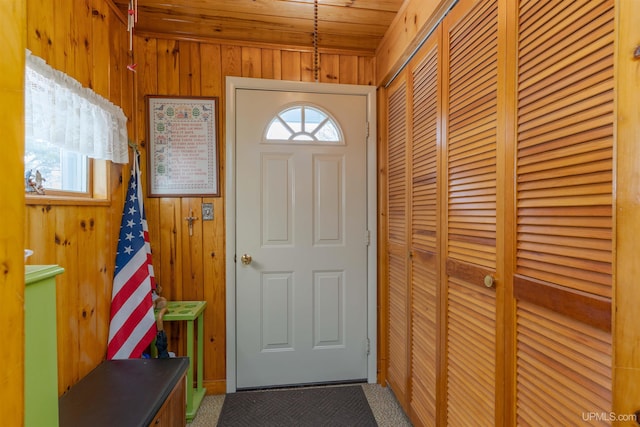 doorway with wood walls and carpet