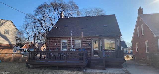 rear view of property featuring a gate, brick siding, a shingled roof, and fence