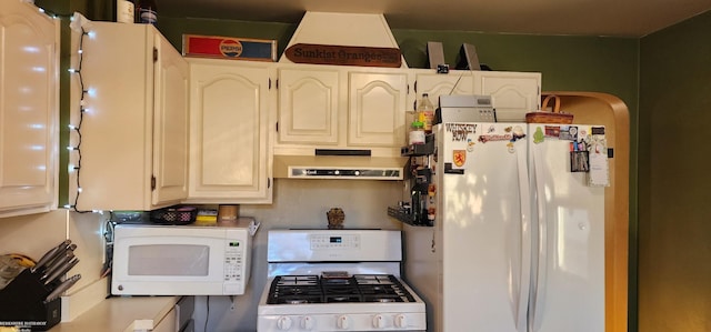 kitchen with white appliances, exhaust hood, and arched walkways