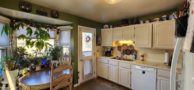 kitchen featuring dishwasher, light countertops, and a sink