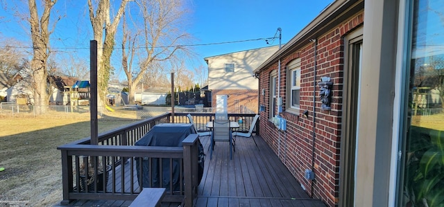 wooden terrace featuring a yard and fence