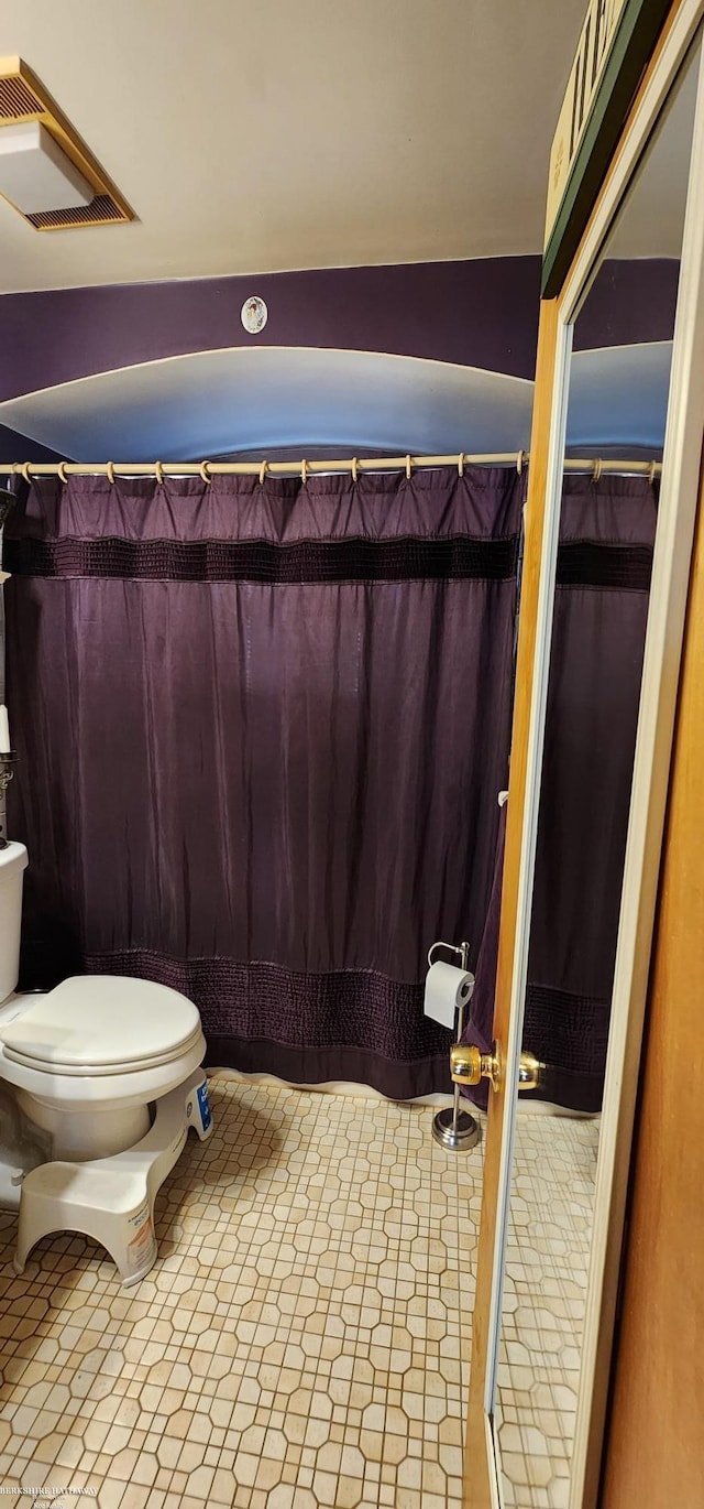 full bathroom featuring a shower with curtain and toilet