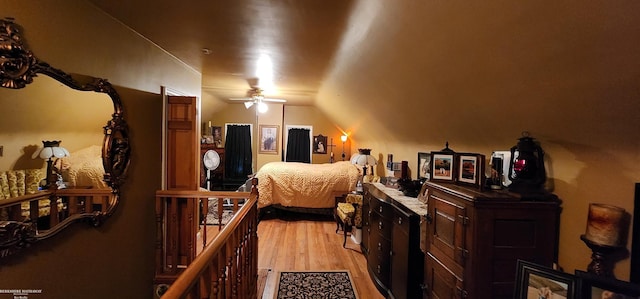 bedroom with vaulted ceiling and light wood-style floors