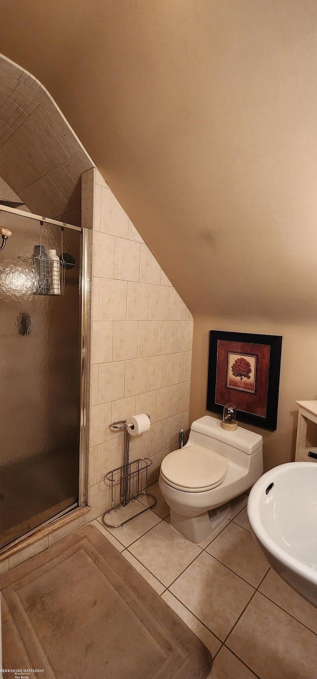 full bathroom featuring tile patterned floors, a stall shower, toilet, and vaulted ceiling