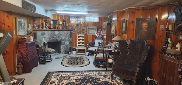 living room with wood walls, a fireplace, and carpet