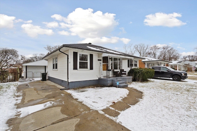 view of front of property featuring a detached garage, an outdoor structure, and fence