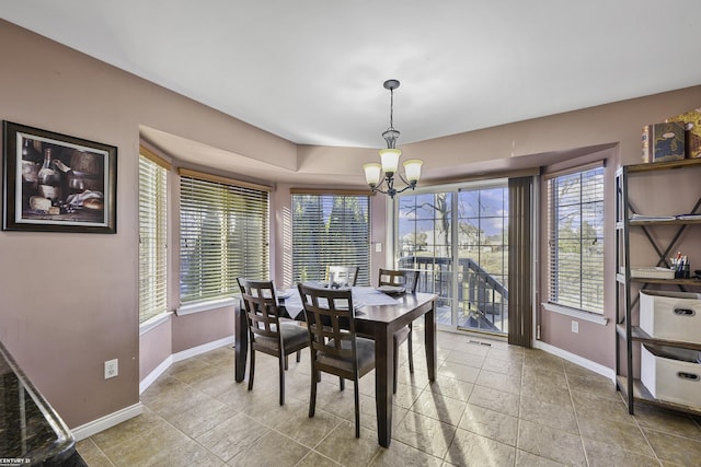 dining area with baseboards and an inviting chandelier