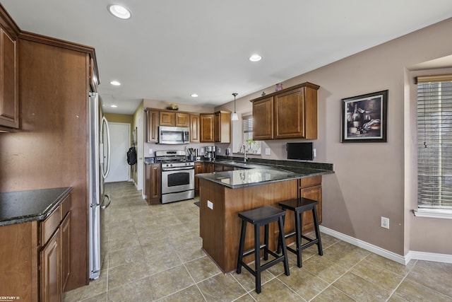 kitchen featuring a breakfast bar, a peninsula, recessed lighting, and appliances with stainless steel finishes