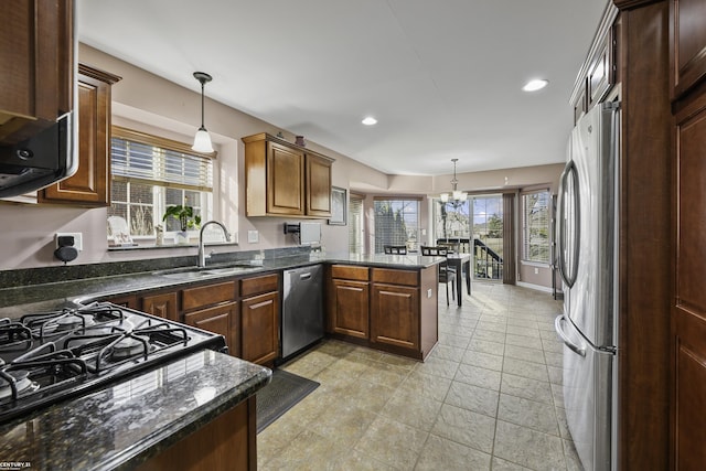 kitchen featuring a sink, appliances with stainless steel finishes, a peninsula, and a healthy amount of sunlight