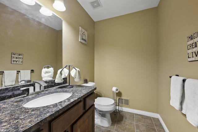 half bathroom with visible vents, toilet, vanity, and tile patterned flooring