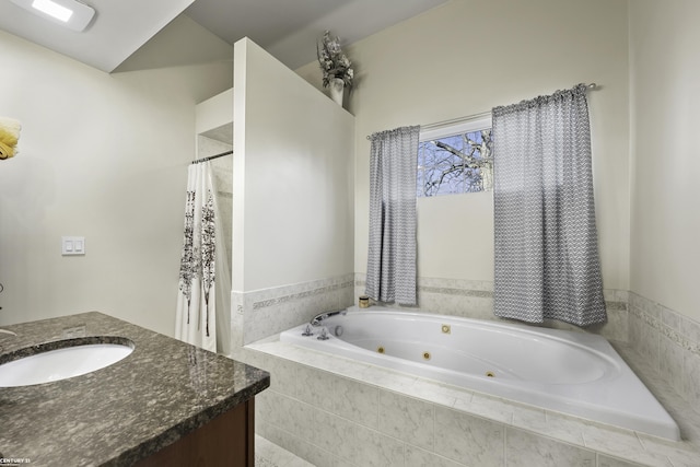 bathroom with a tile shower, a jetted tub, and vanity