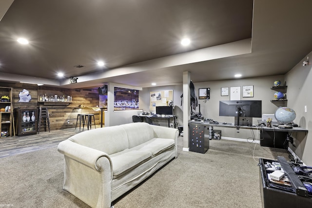 carpeted living room featuring a bar, recessed lighting, baseboards, and wood walls