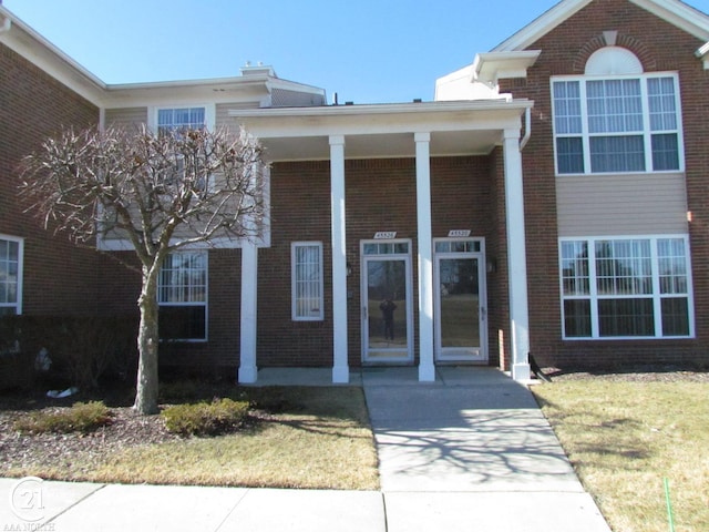 view of front of house featuring brick siding and a front yard