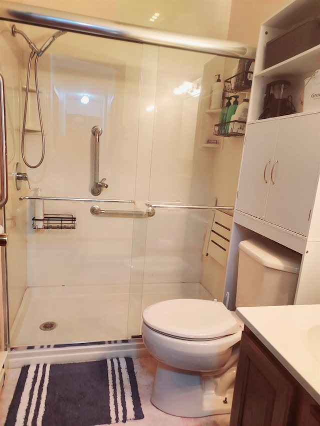 full bath with toilet, a stall shower, and vanity