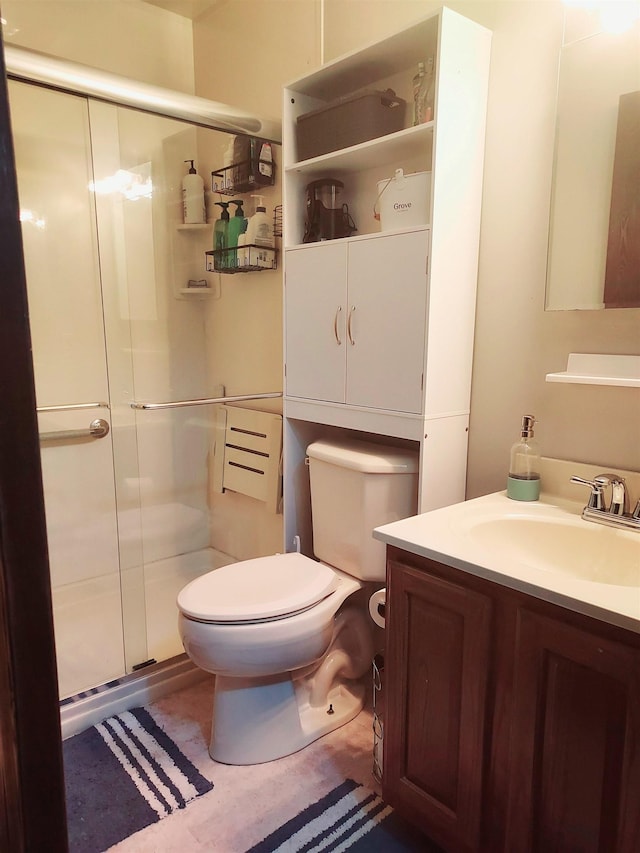 bathroom with vanity, toilet, and a stall shower