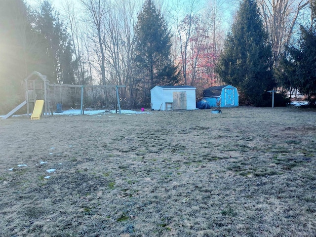 view of yard featuring an outdoor structure, a playground, and a shed