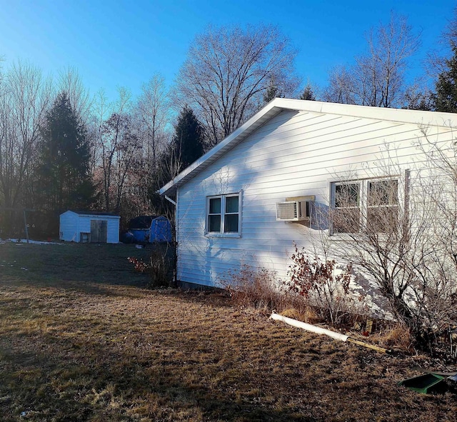 view of property exterior with a lawn and a wall unit AC