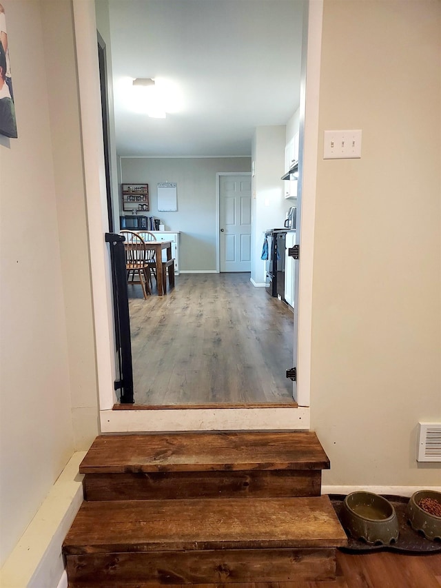 staircase featuring wood finished floors and visible vents