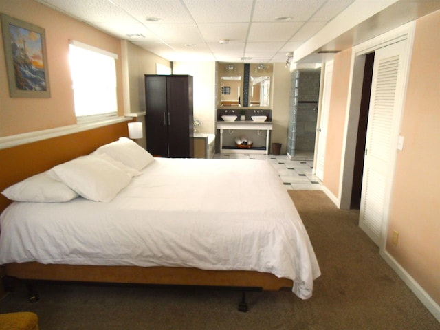 bedroom featuring a paneled ceiling, baseboards, and carpet floors