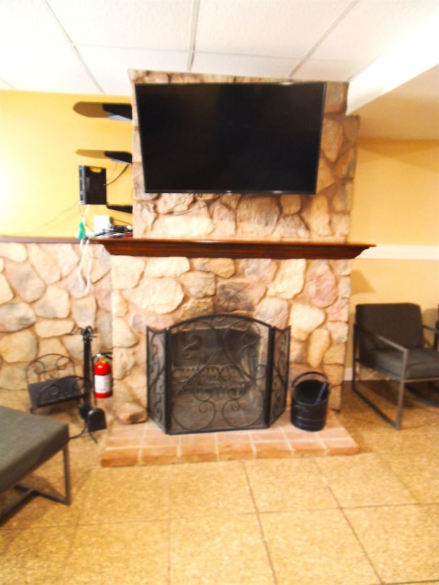 details featuring a paneled ceiling and a stone fireplace