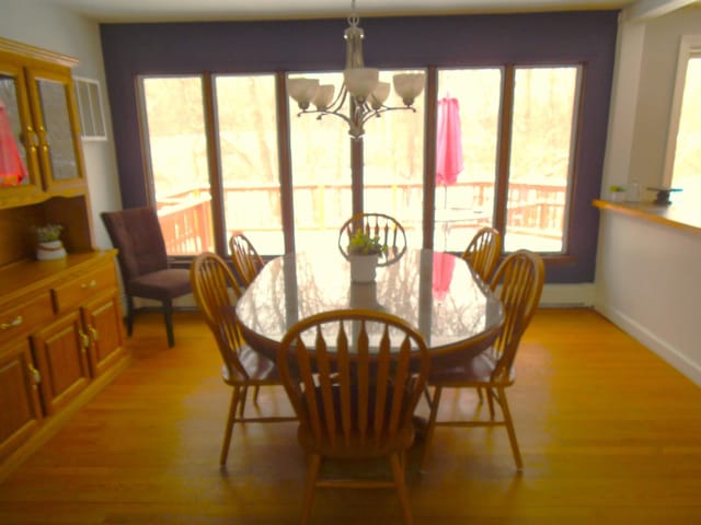 dining area featuring light wood-style flooring, a notable chandelier, and baseboards