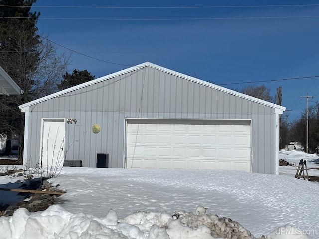 snow covered garage with a garage