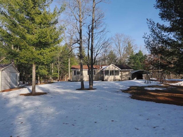 view of yard with an outbuilding, a carport, driveway, and a shed