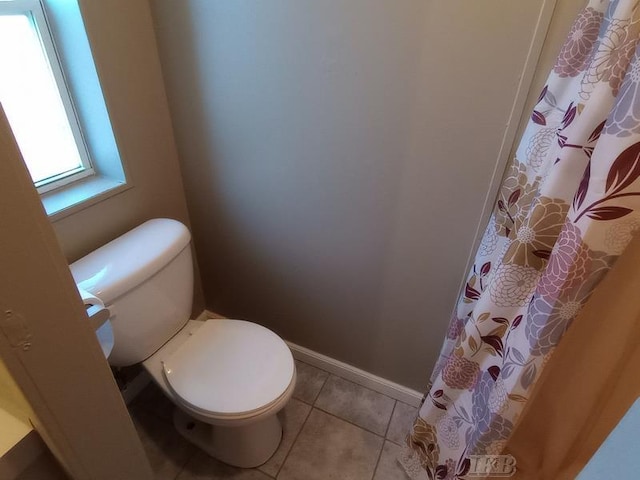 full bathroom featuring tile patterned floors, toilet, and baseboards