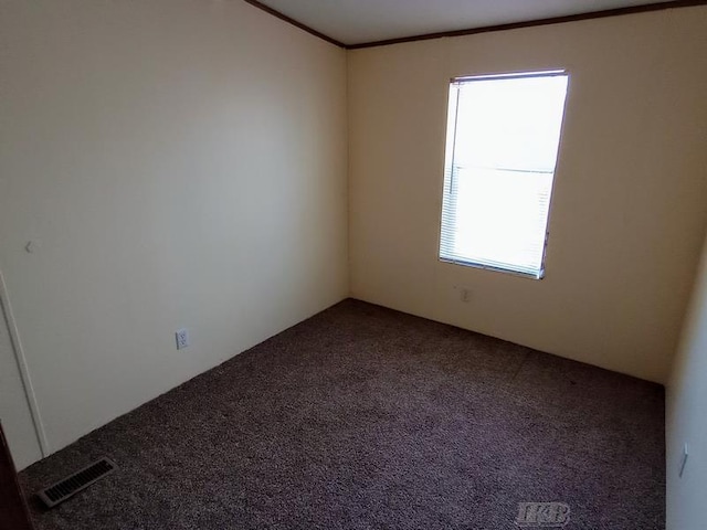 carpeted empty room with visible vents and crown molding