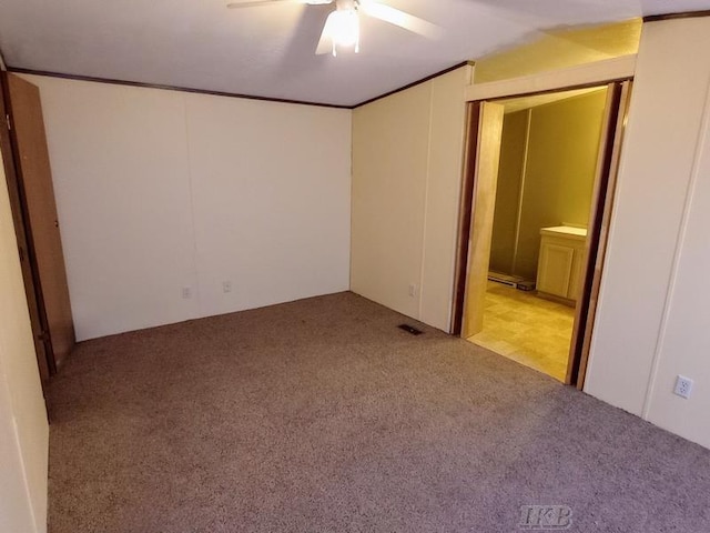 unfurnished bedroom with visible vents, carpet, ornamental molding, ensuite bathroom, and a ceiling fan