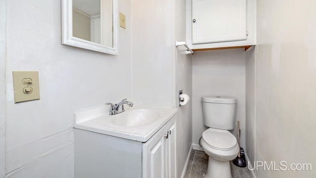 bathroom featuring baseboards, toilet, and vanity