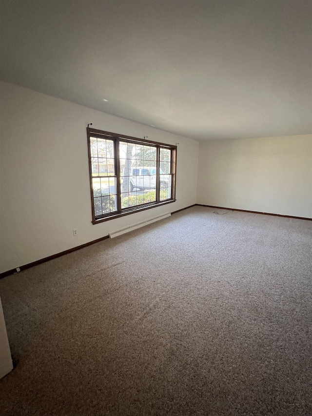 carpeted spare room featuring baseboards