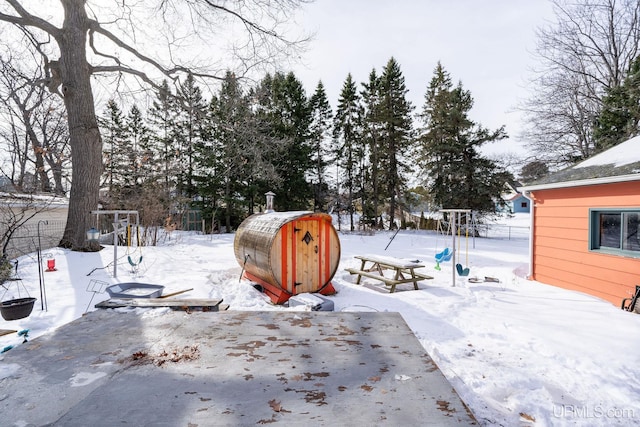 snowy yard with an outbuilding and a shed