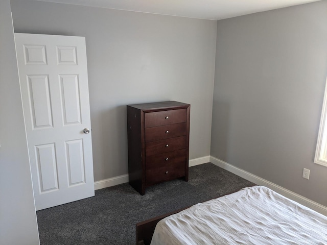 bedroom with baseboards and dark colored carpet