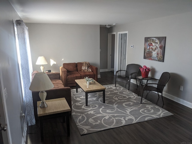 living area with baseboards and wood finished floors