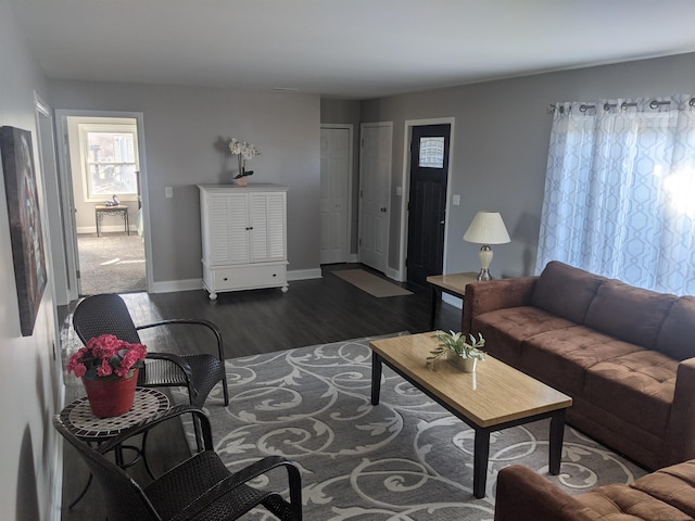 living room with baseboards and dark wood-style flooring