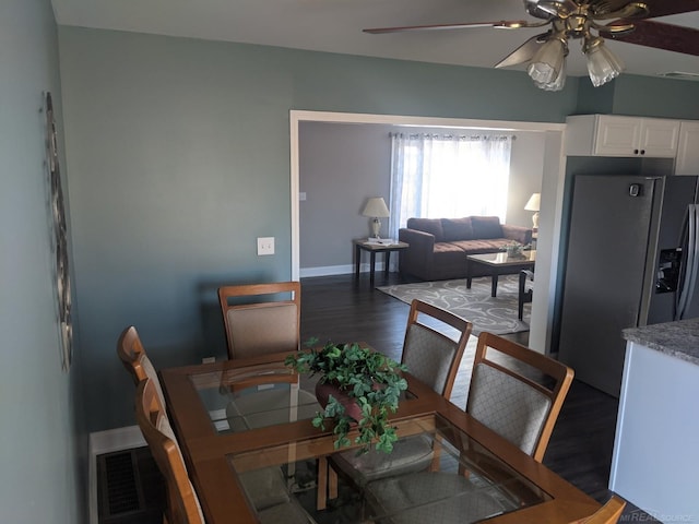 dining room featuring visible vents, baseboards, a ceiling fan, and wood finished floors