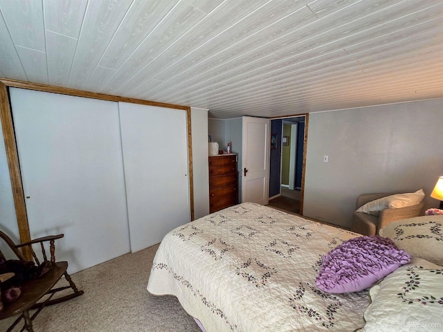 bedroom featuring wooden ceiling, carpet flooring, and a closet