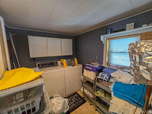 laundry area featuring cabinet space, washer and dryer, and wallpapered walls