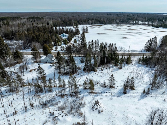 snowy aerial view featuring a forest view