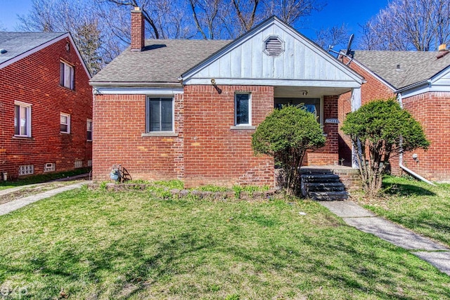 bungalow featuring brick siding, board and batten siding, a front yard, roof with shingles, and a chimney